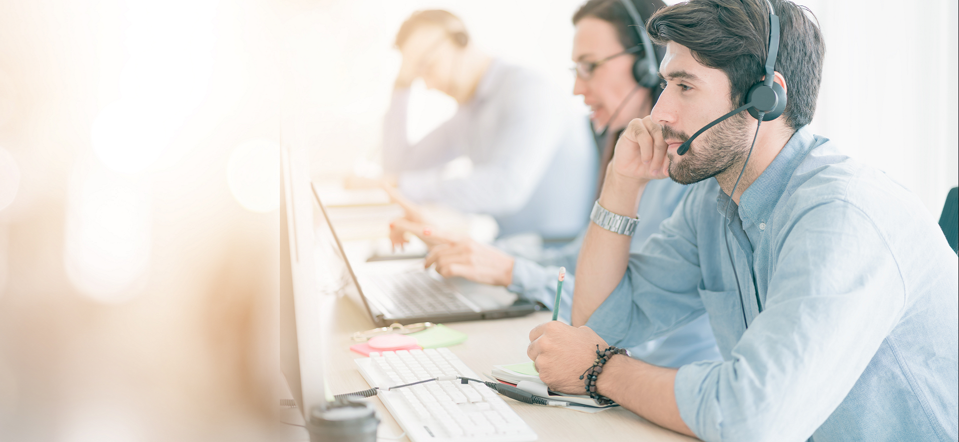 mężczyzna siedzący przy biurku ze słuchawką na głowie