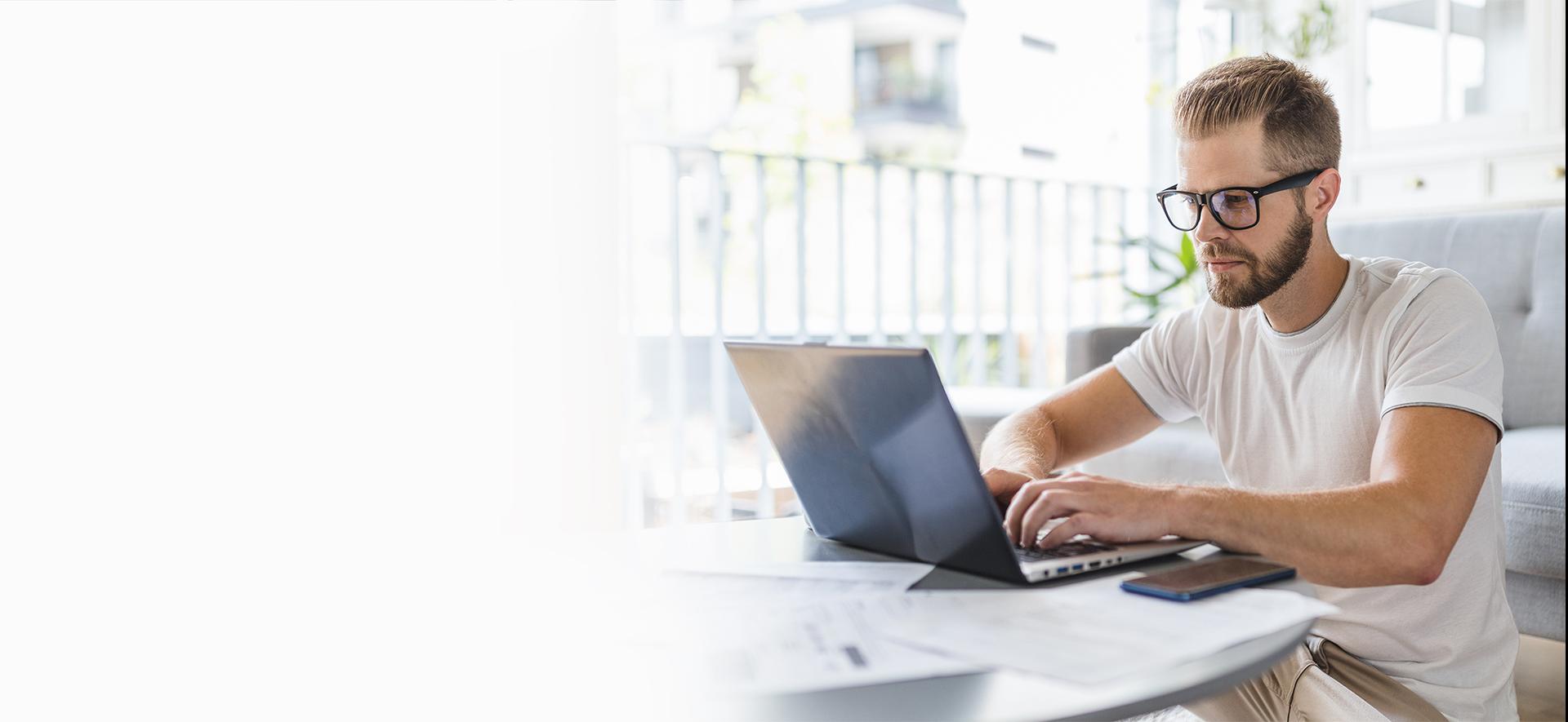 mężczyzna siedzący przy laptopie