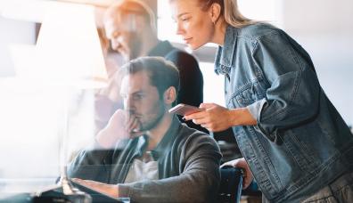 Grupa osób stojąca przy komputerze i patrząca na jego ekran