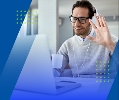 mężczyzna wita się, machając ręką przed ekranem komputera 