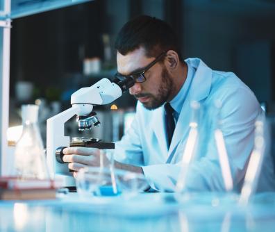 Diagnosta laboratoryjny oglądający próbkę przez mikroskop