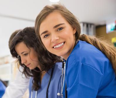 młoda lekarka uśmiechająca się i patrząca w stronę obiektywu