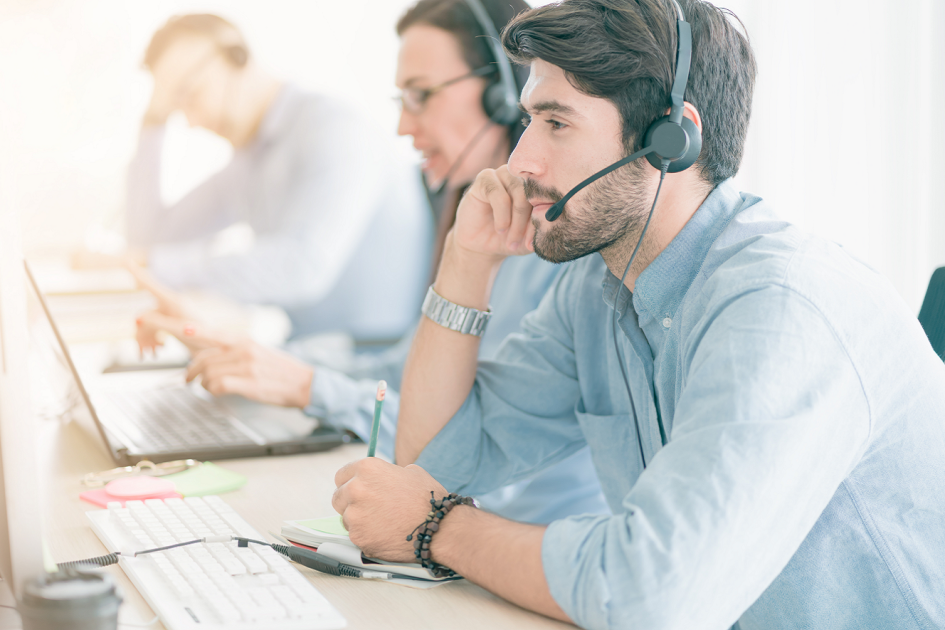 mężczyzna siedzący przy biurku ze słuchawką na głowie