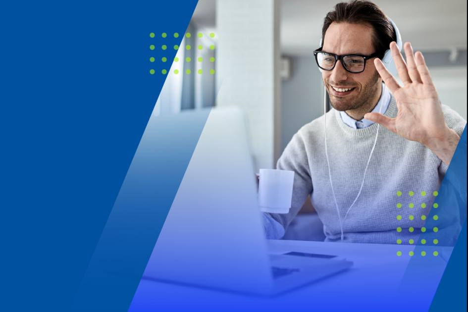 mężczyzna wita się, machając ręką przed ekranem komputera 